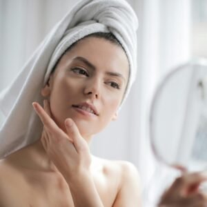 A serene and elegant woman enjoys a skincare ritual, enhancing her natural beauty in the comfort of her home.